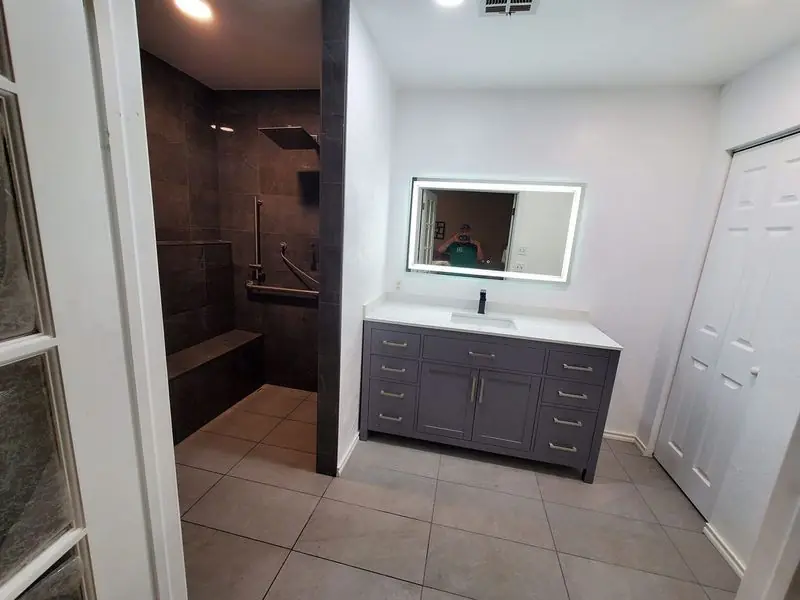 Primary bathroom with a tiled walk-in shower and a grey double vanity