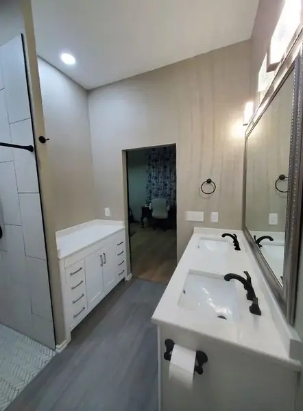 Double-sink vanity and matching walk-in shower in a completed TLC Renovation bathroom