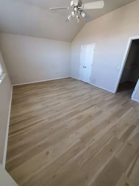 Vaulted-ceiling bedroom finished with new wood-look flooring